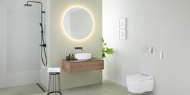 Ein modernes Badezimmer mit einer eleganten Dusche, einem runden Spiegel und einer stilvollen Holzwaschbeckenablage.