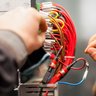 Ein Elektroniker der an einem Verteilerkasten arbeitet